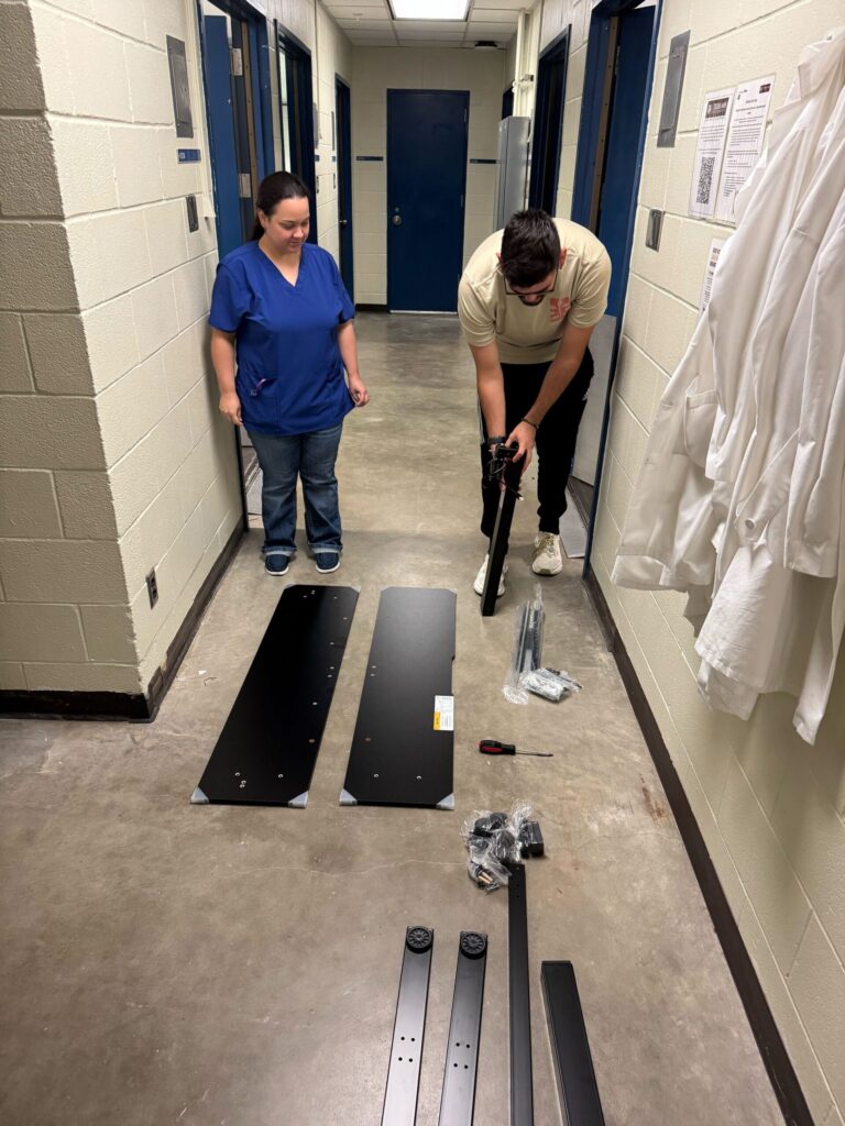 Islyn Gilmore and Jacob DeVargas laying out parts to build a sit/stand desk.